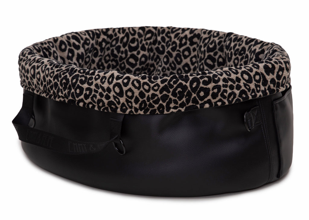  Wau-Snuggle Reisebett mit robustem schwarzen Kunstleder an der Außenseite und einem weichen, beigen Innenfutter mit schwarzem Leopardenmuster in oval Rückseite

