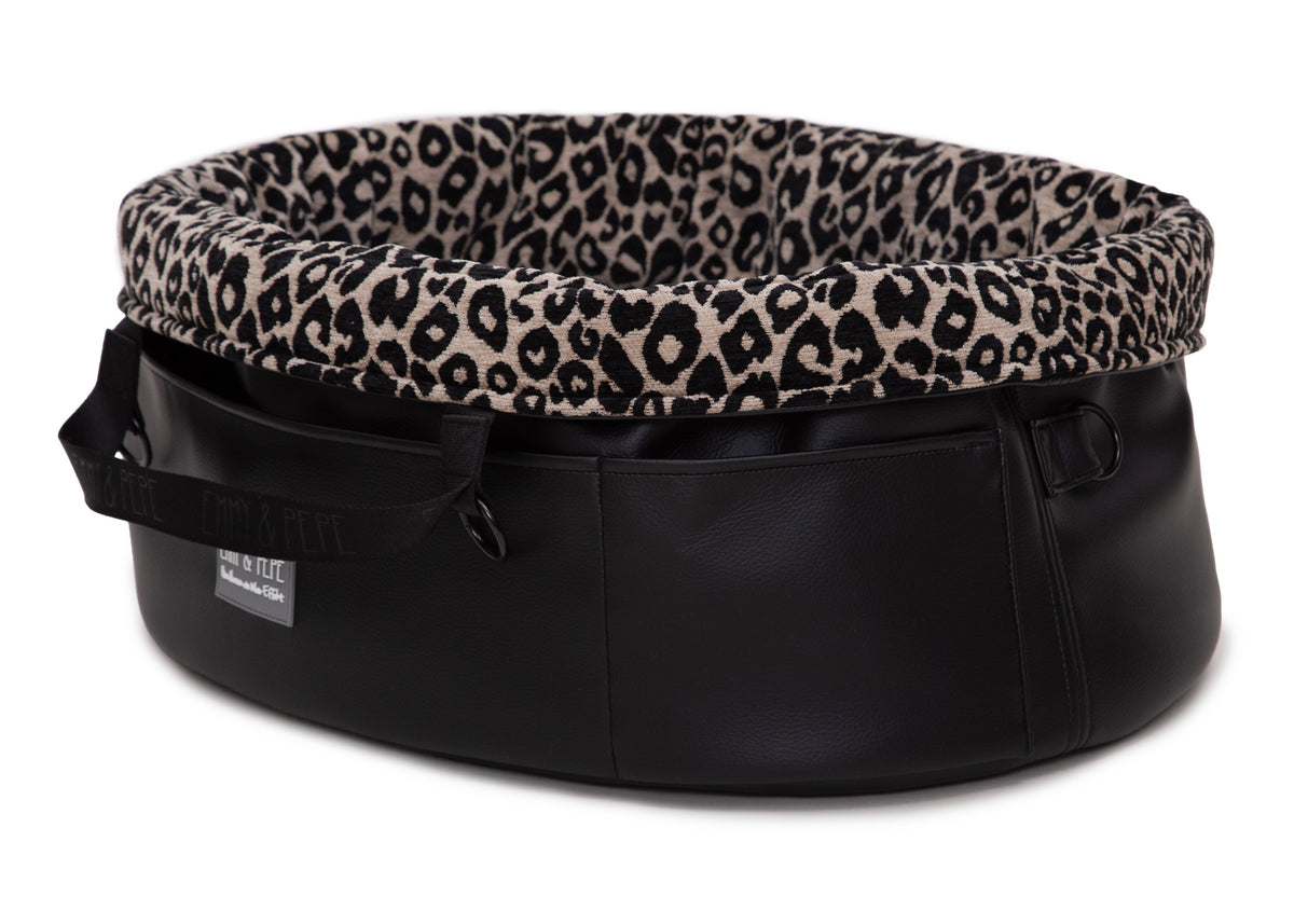  Wau-Snuggle Reisebett in oval mit robustem schwarzen Kunstleder an der Außenseite und einem weichen, beigen Innenfutter mit schwarzem Leopardenmuster 